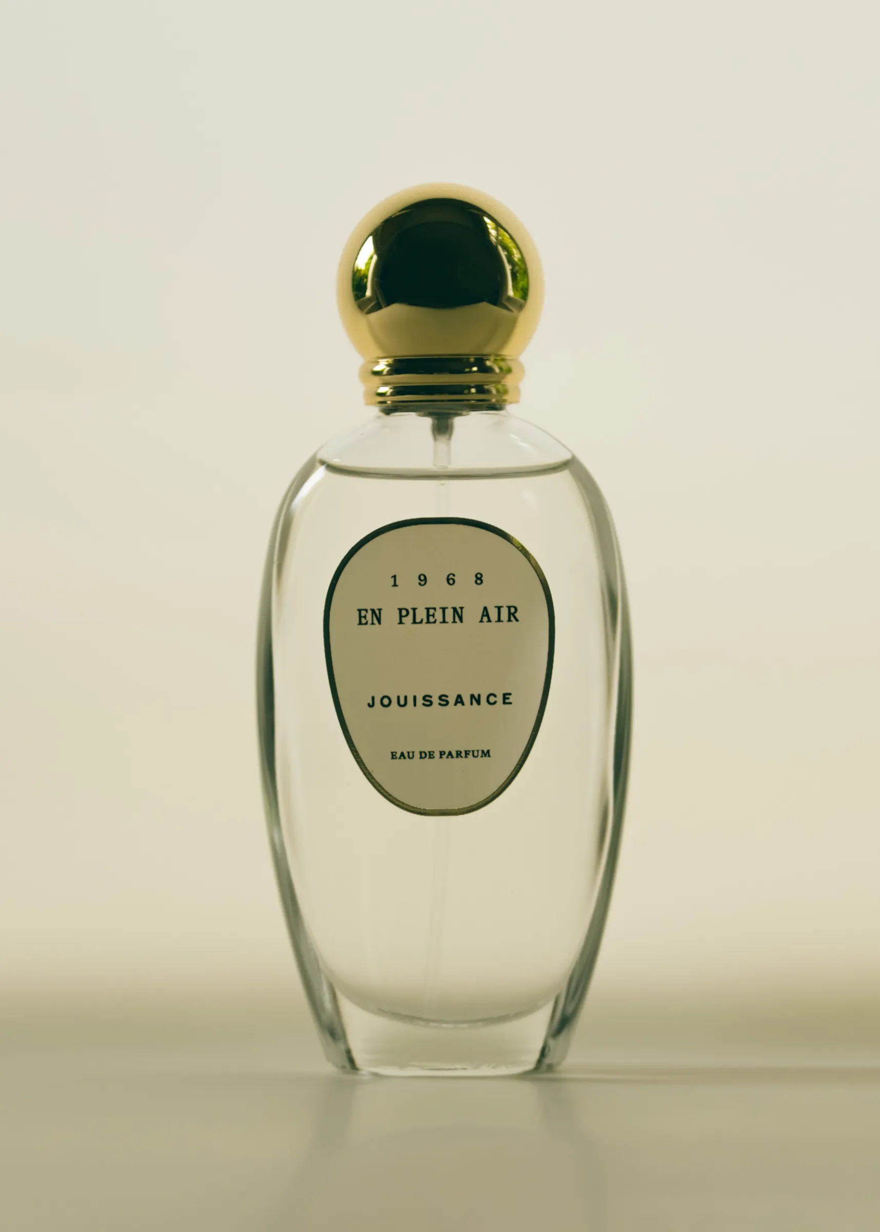 Bottle of En Plein Air by Jouissance, with a simple curved label and circular gold cap