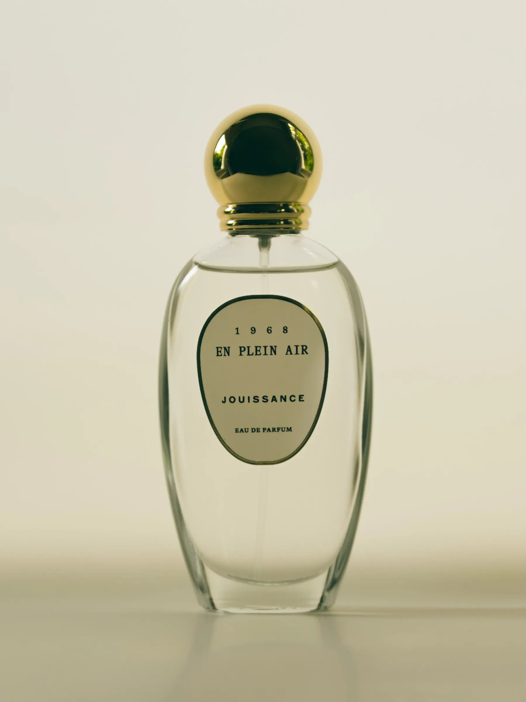 Bottle of En Plein Air by Jouissance, with a simple curved label and circular gold cap
