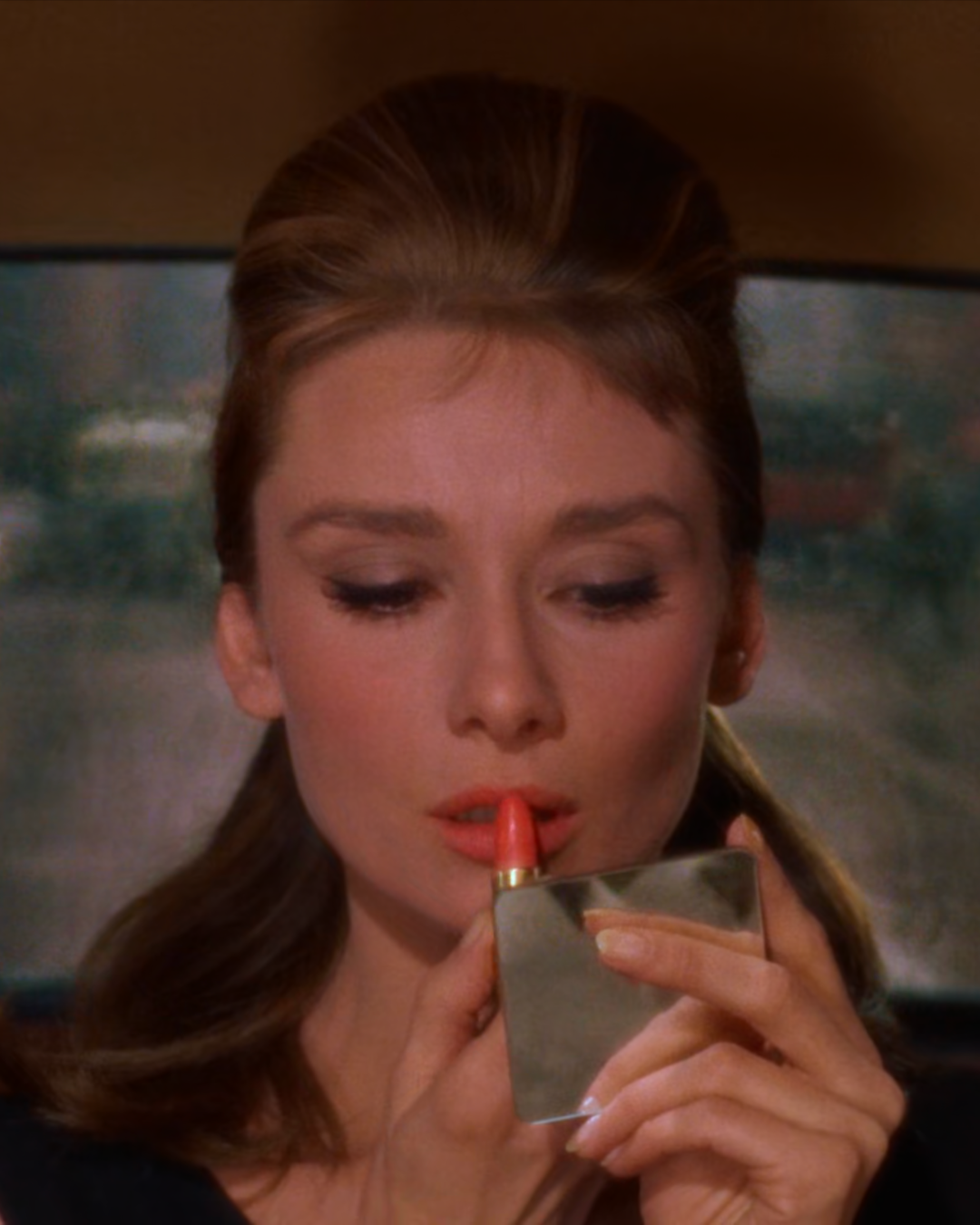 Audrey Hepburn Applying Lipstick in a Compact