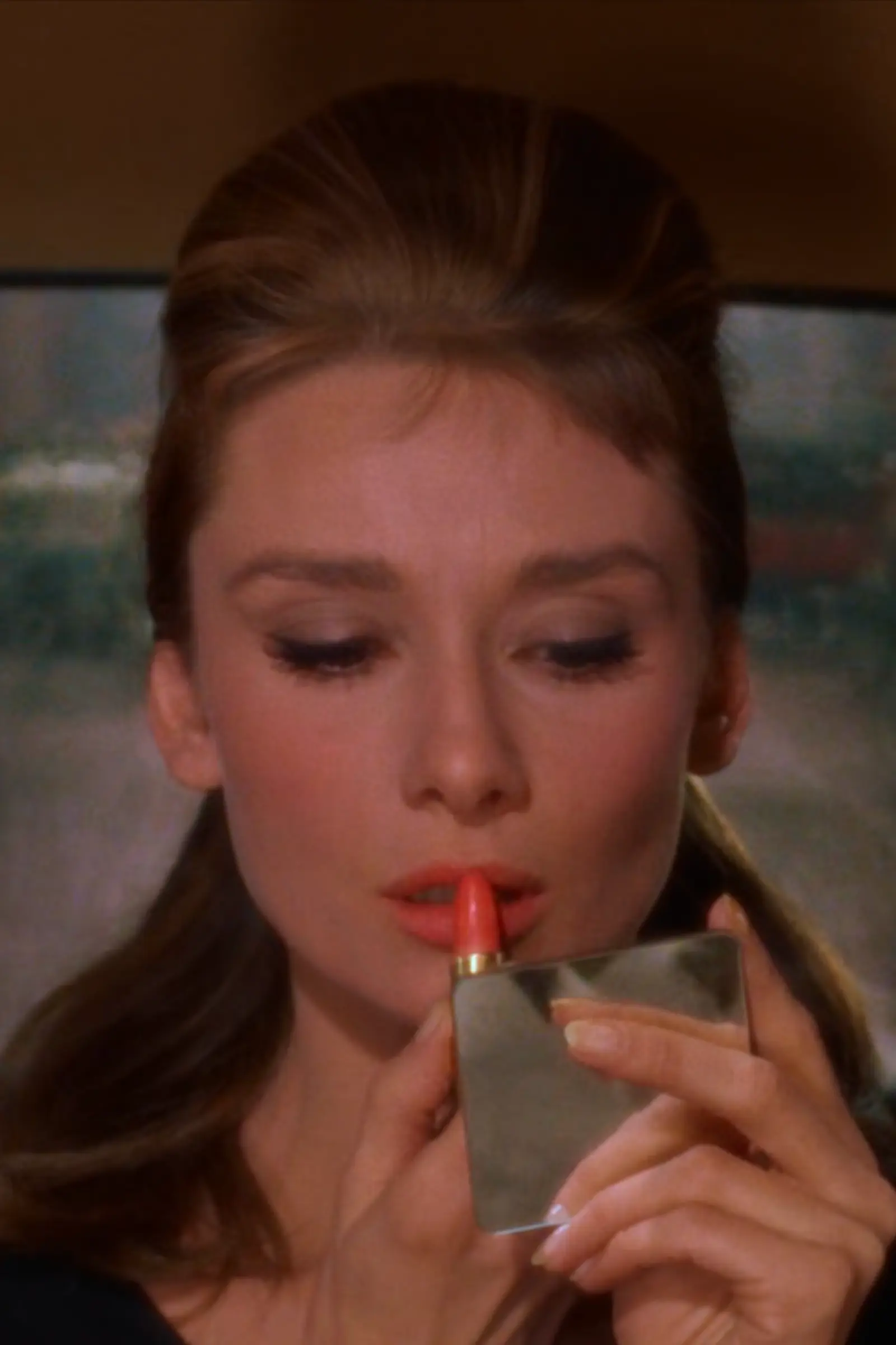 Audrey Hepburn Applying Lipstick in a Compact