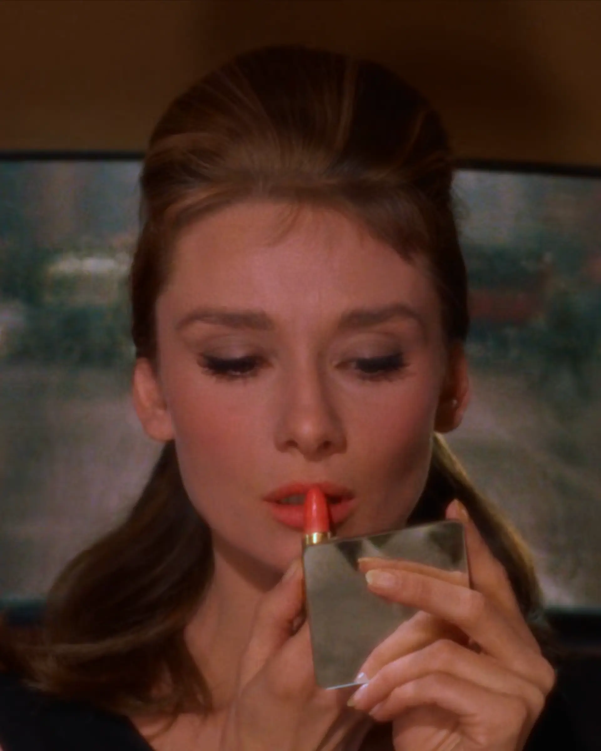 Audrey Hepburn Applying Lipstick in a Compact
