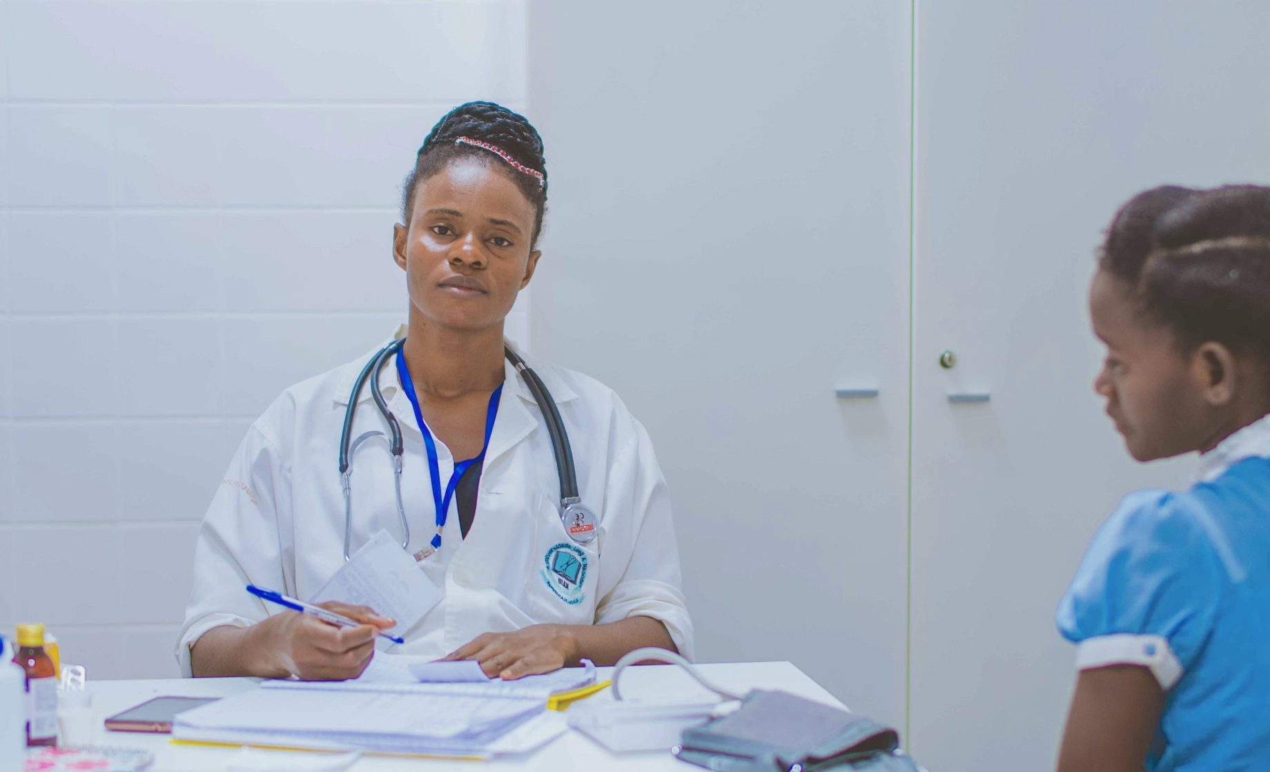 A smiling doctor talking with a young patient in a bright clinic
