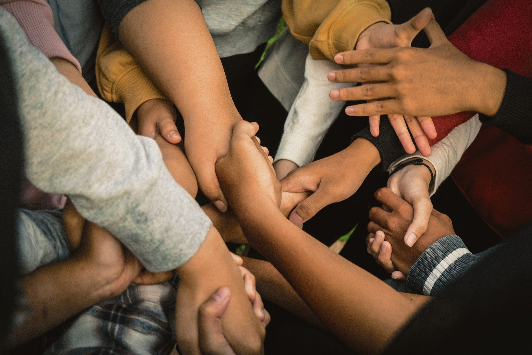 Many hands joined together in a circle