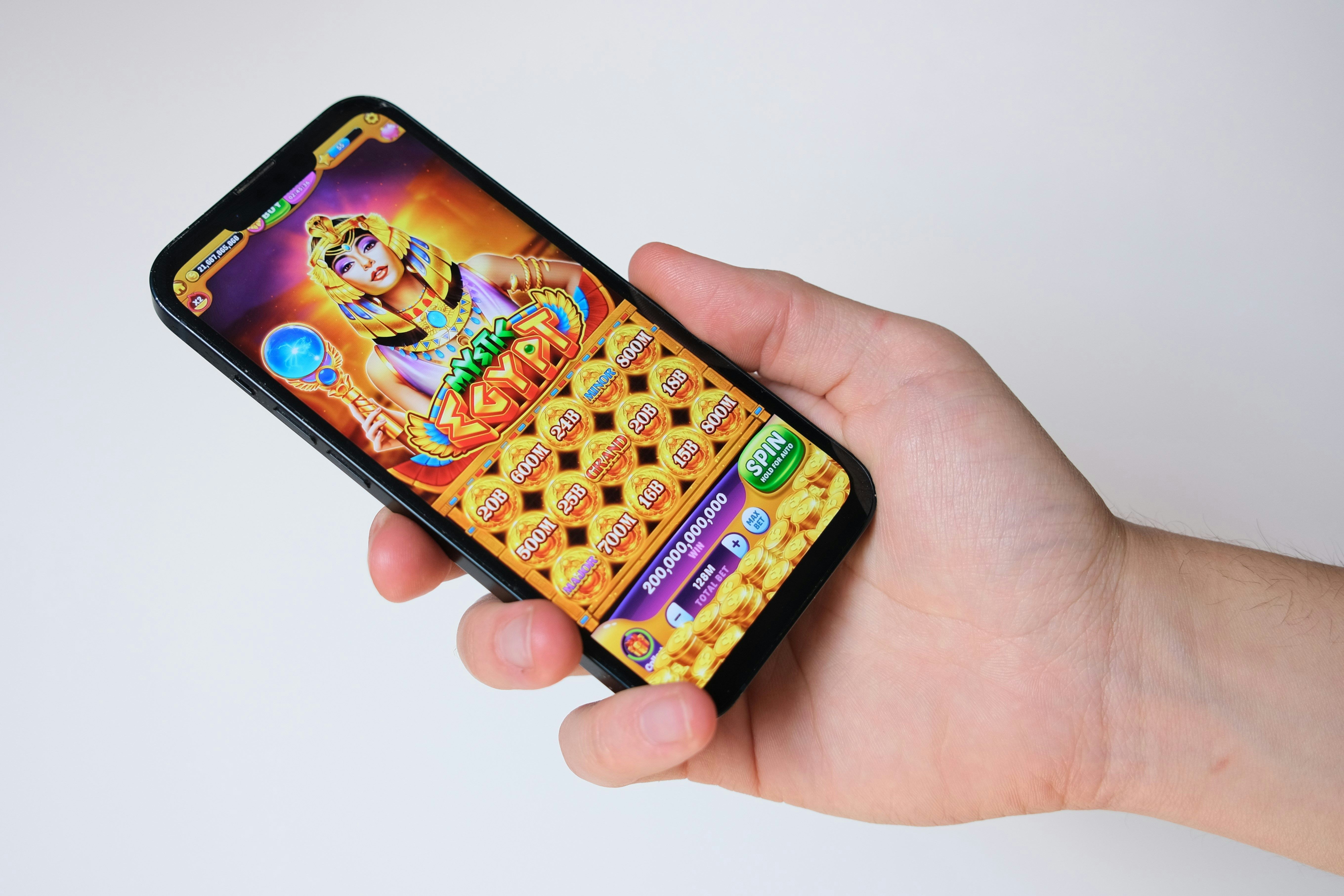 a person is holding a cell phone with a game on it .