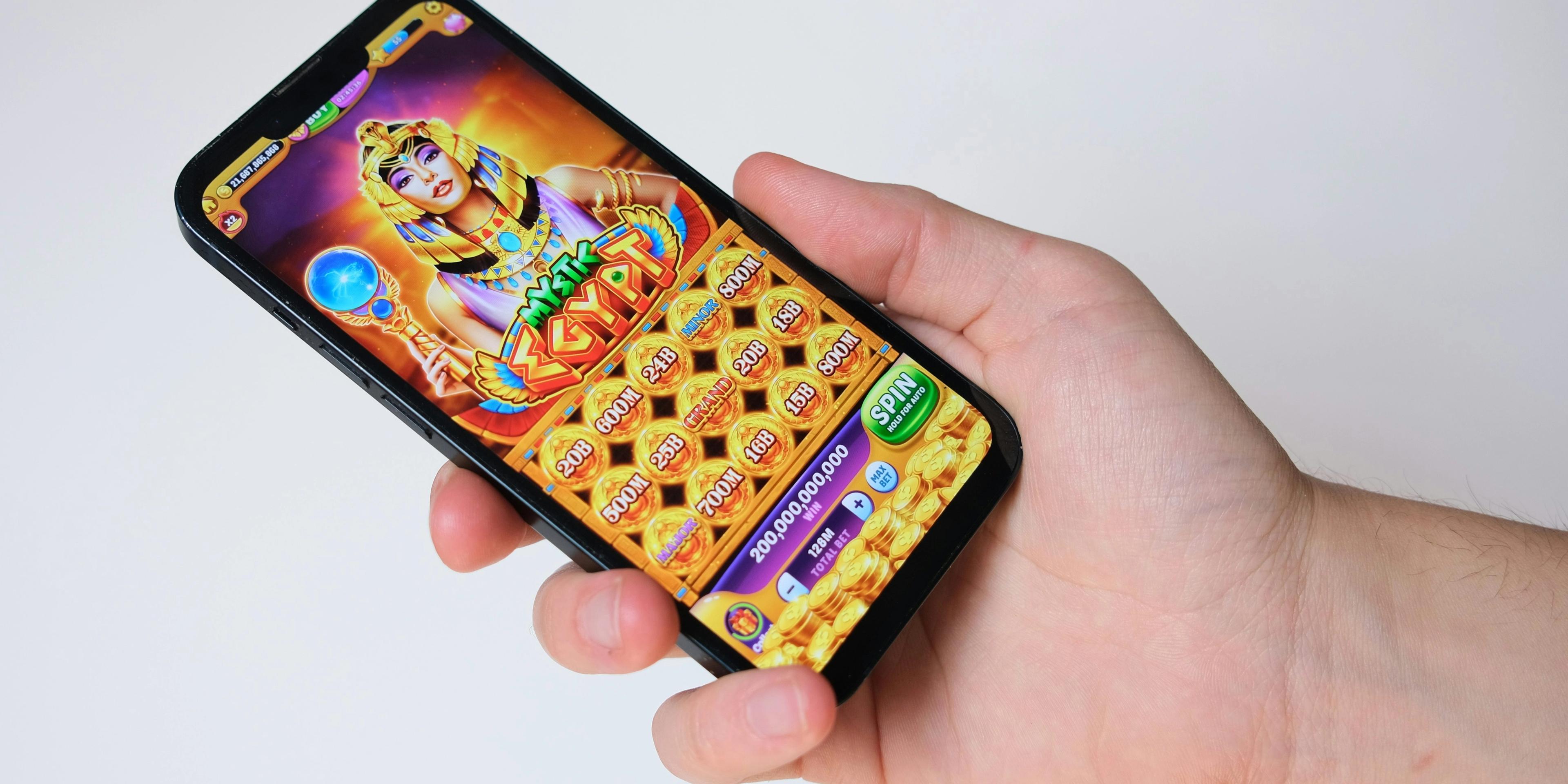 a person is holding a cell phone with a game on it .