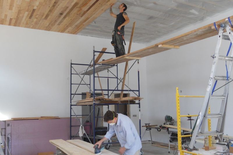 Cory and Mark prep and lay ceiling boards at the Retreat Center 