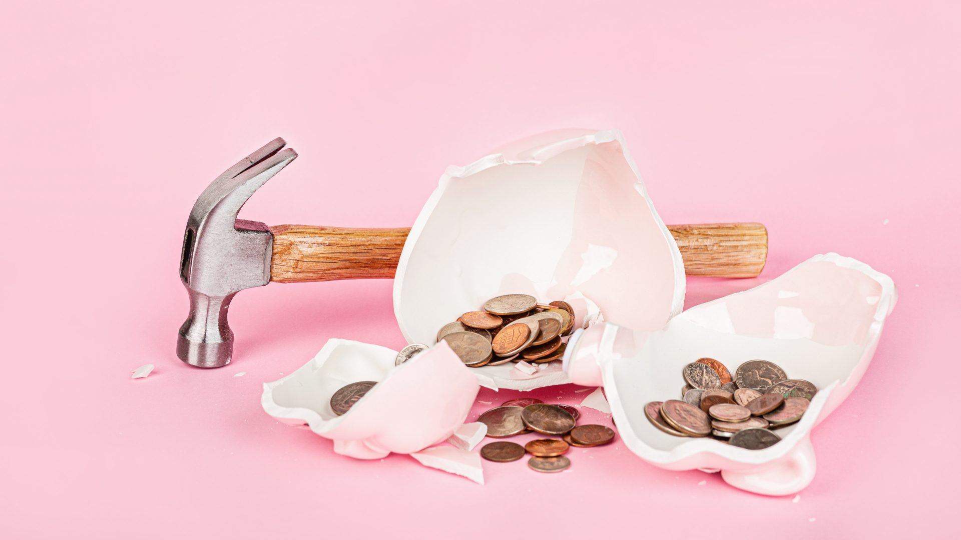 Broken piggy bank with cash coins money on pink background