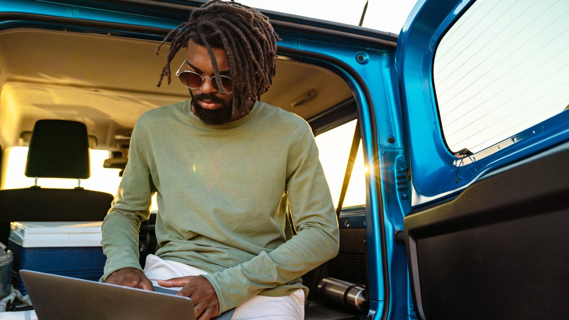 Image of man using laptop while travelling with car