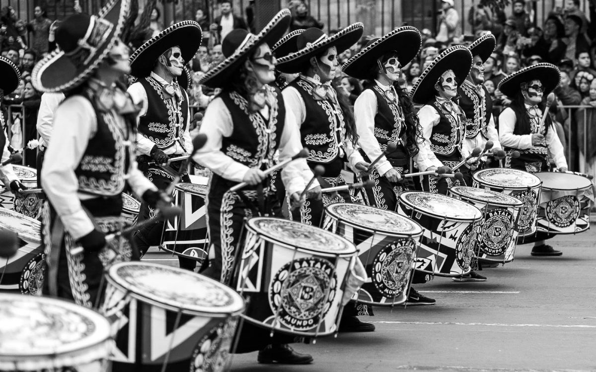 Line of drummers in embroidered outfits and sombreros at a Day of the Dead parade