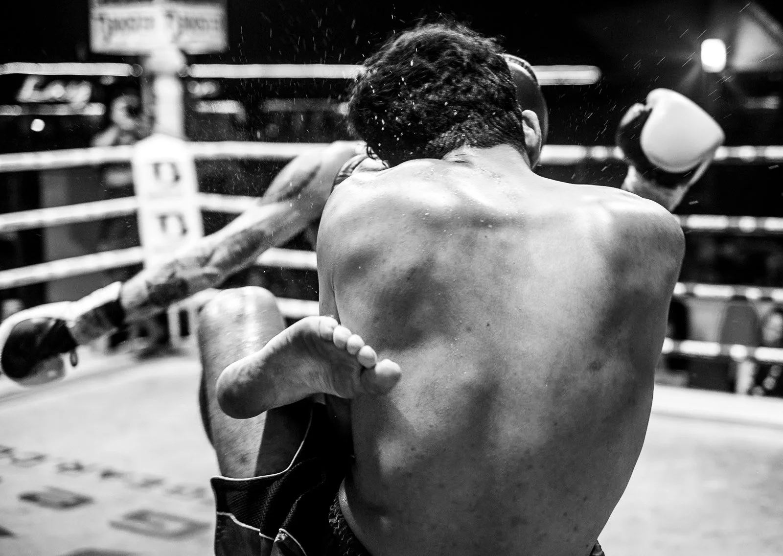 Muay Thai fighters clinch as one raises his knee