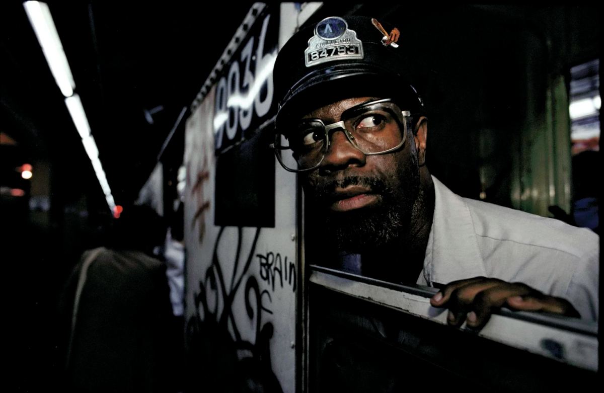 Bruce Davidson photograph of a man in glasses looking through a subway train doorway