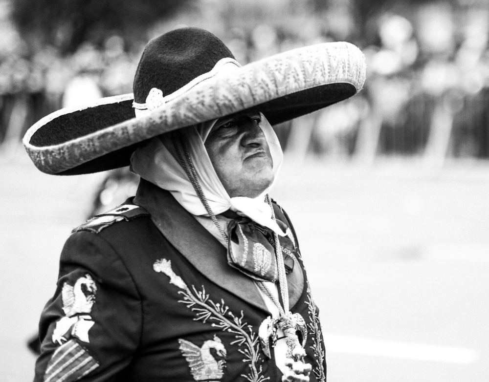 Day of the Dead participant wearing an embroidered outfit and a wide sombrero