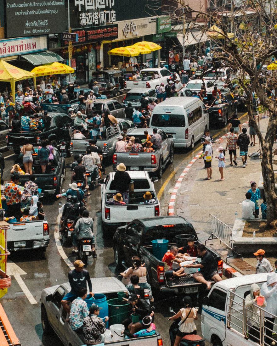 Pickup trucks carrying water tanks crowd a Chiang Mai street during Songkran
