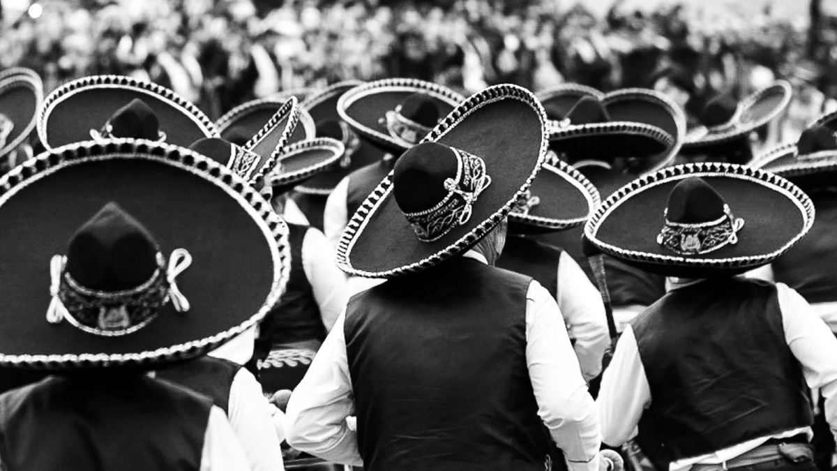 Back view of parade participants wearing wide sombreros during Day of the Dead