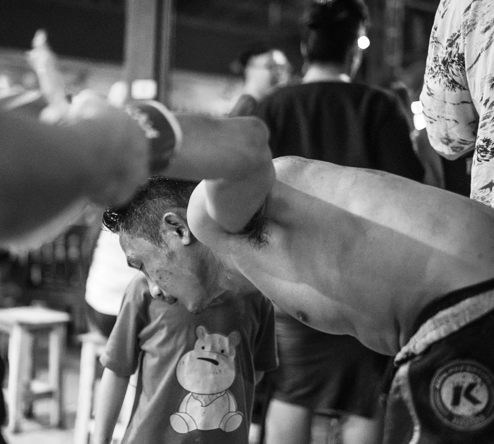 Muay Thai fighter bends down to speak to his son after the fight