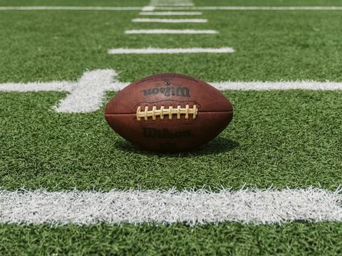 Football resting on a marked football field