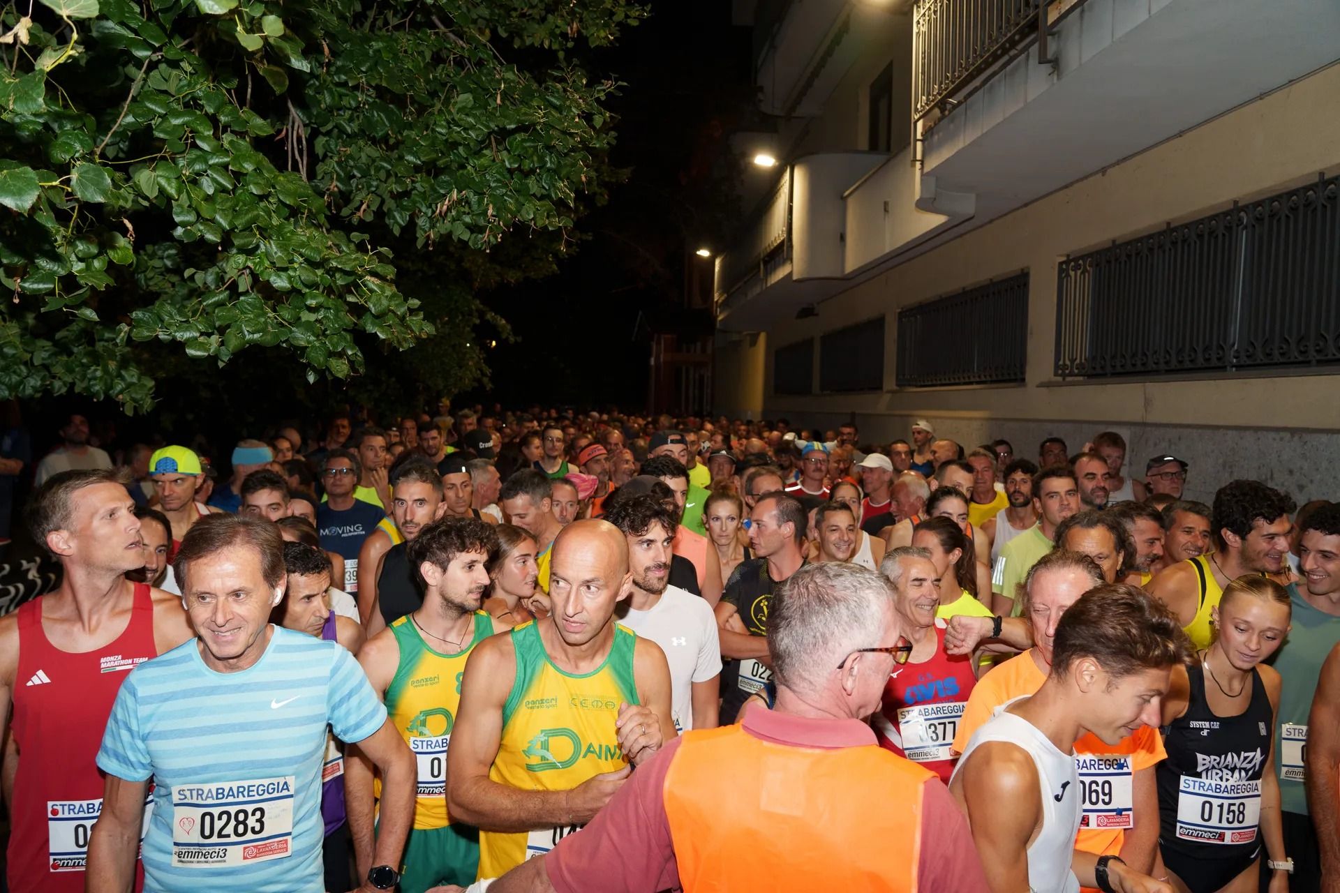 Partenza serale di una corsa su strada, con tanti podisti al via