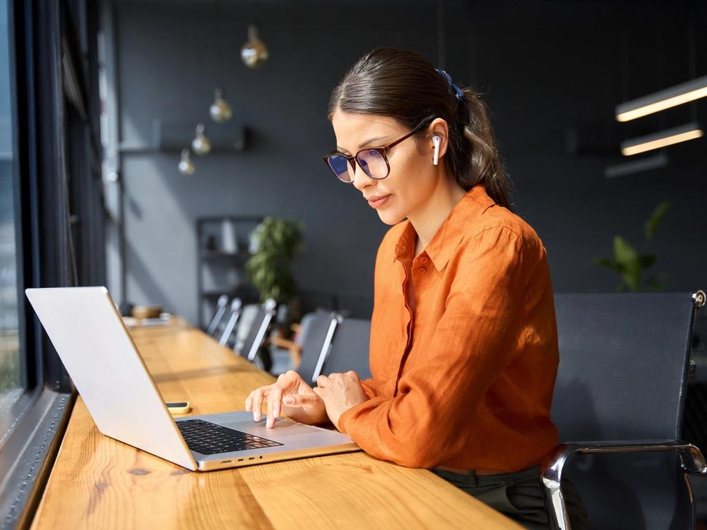 Professional woman using laptop for communication in office