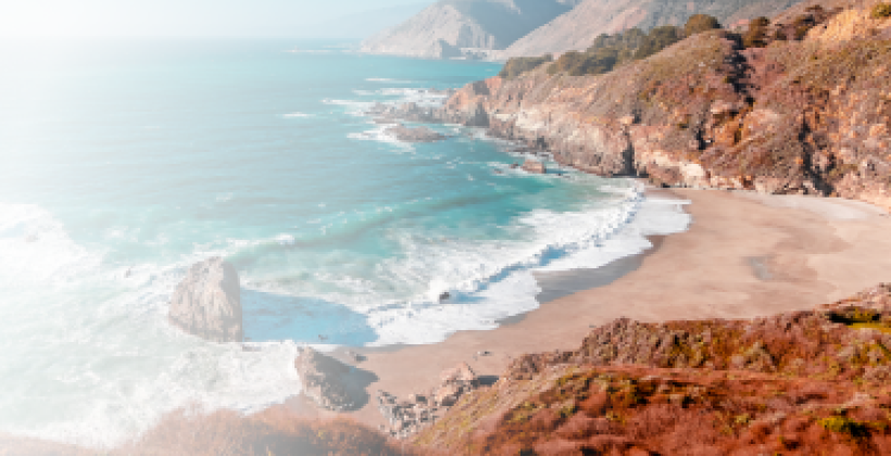 Picture of a beach shore surrounded by a rocky cliff