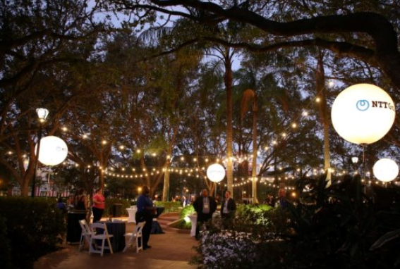 Evening outdoor reception with string lights and palm trees