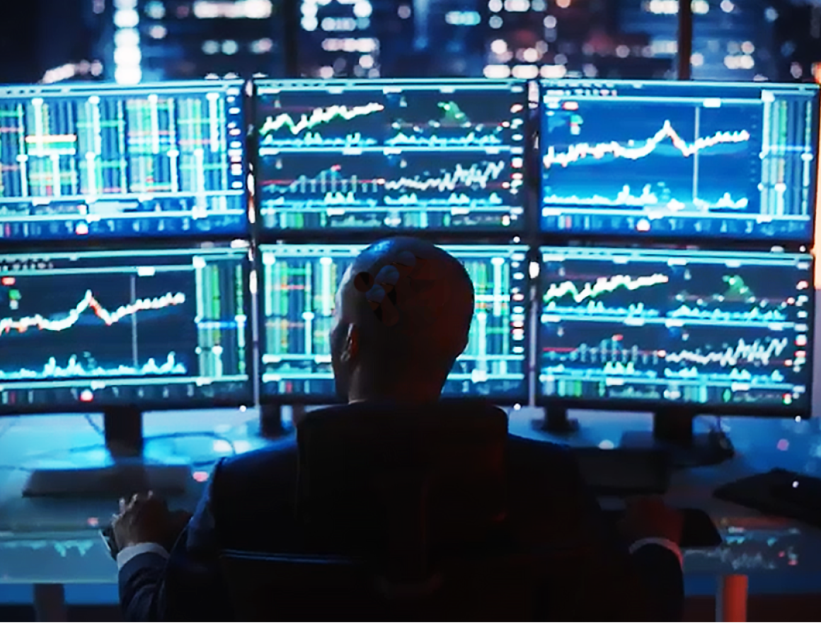 person working with multiple monitors displaying trend charts