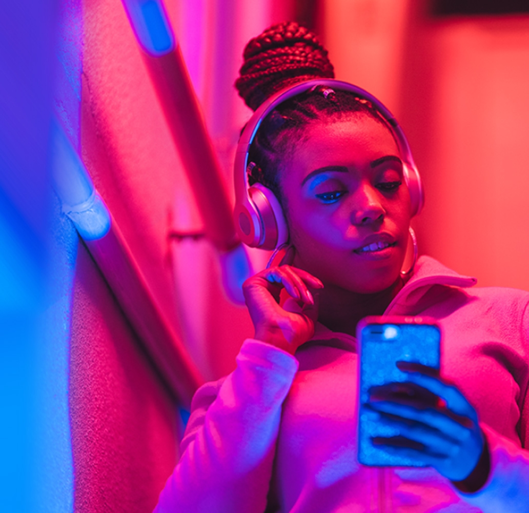 Woman with headphones looking at cellphone