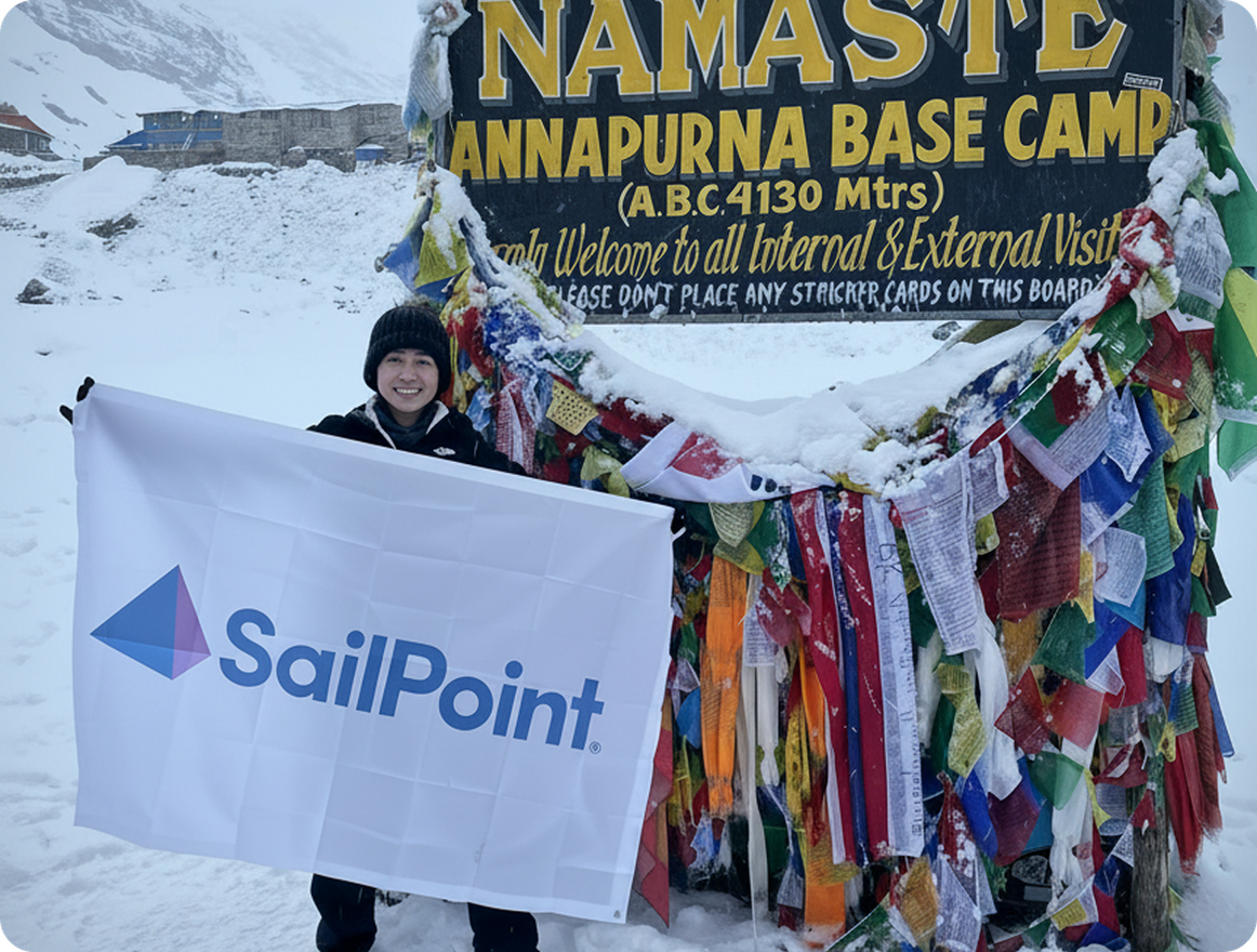 SailPoint employee holding a SailPoint flag at Annapurna Base Camp