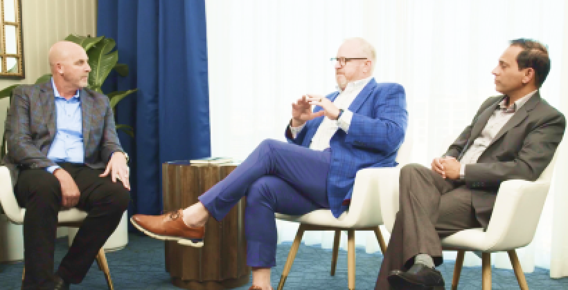 Three men sitting in chairs discussing a topic