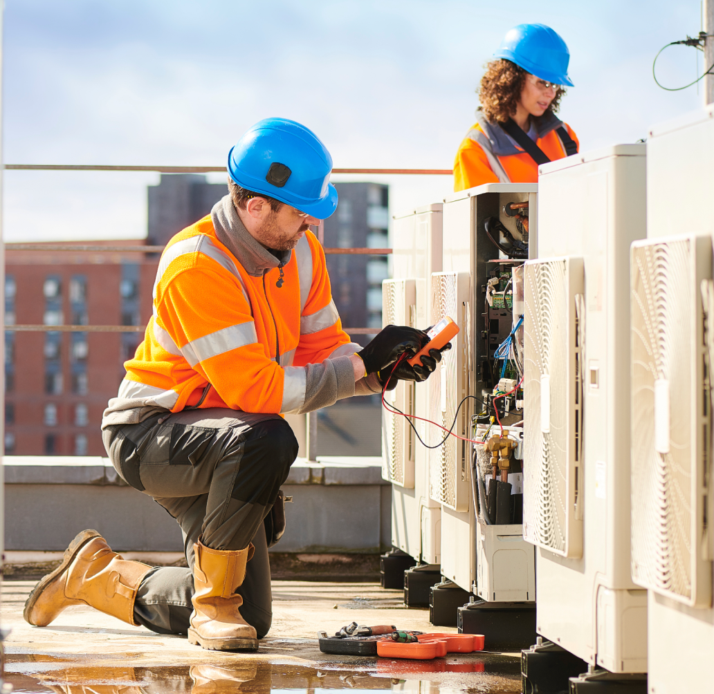Man and woman working on a roof of a commercial building