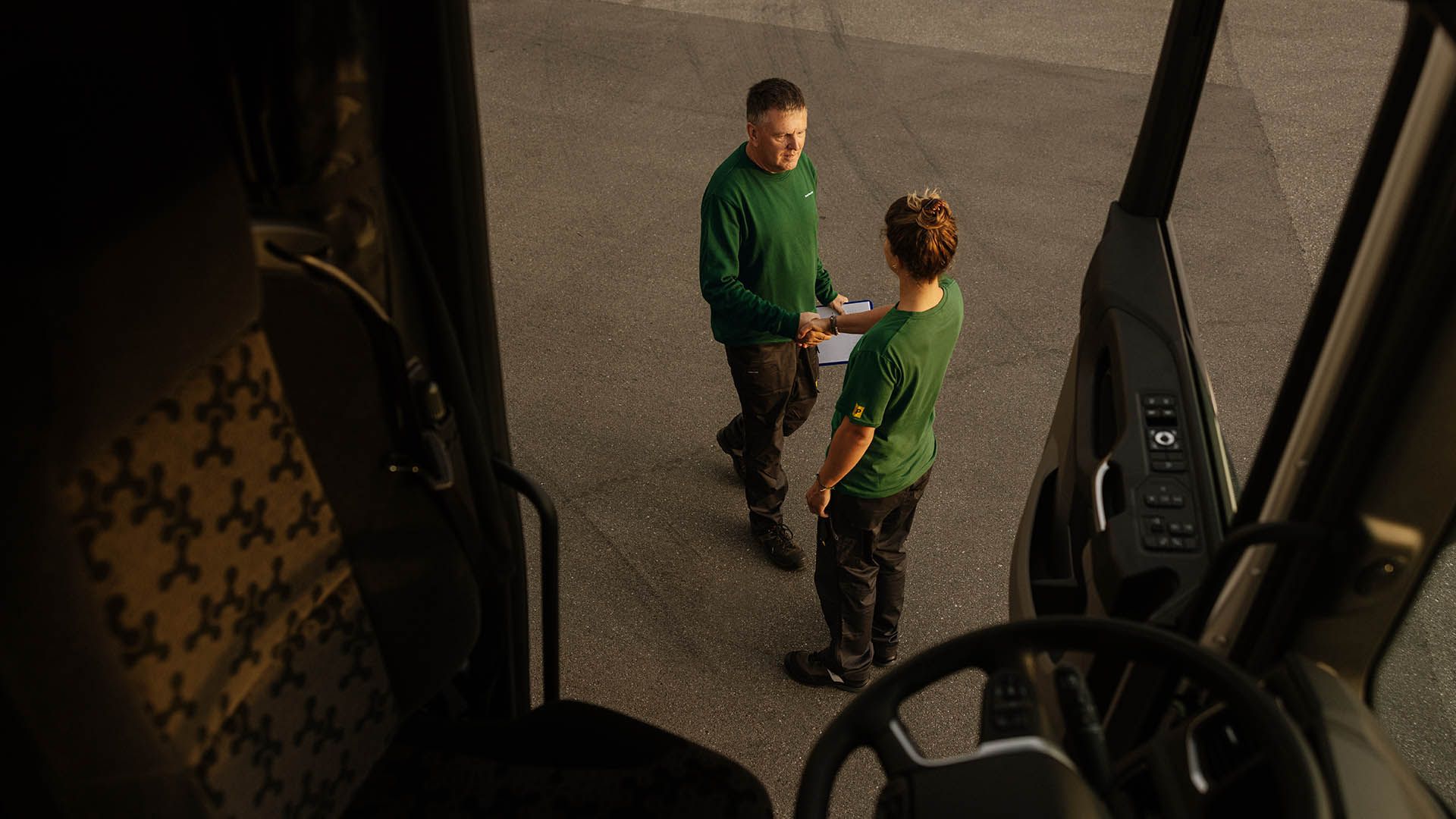 Due collaboratori di Swiss Post Cargo si danno il benvenuto (fotografati dall’autocarro aperto).