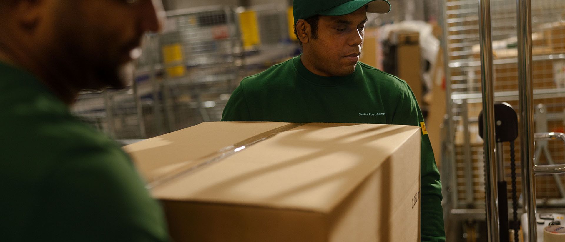 Zwei Mitarbeiter von Swiss Post Cargo stellen über Nacht Waren in einem Ladenlokal zu.