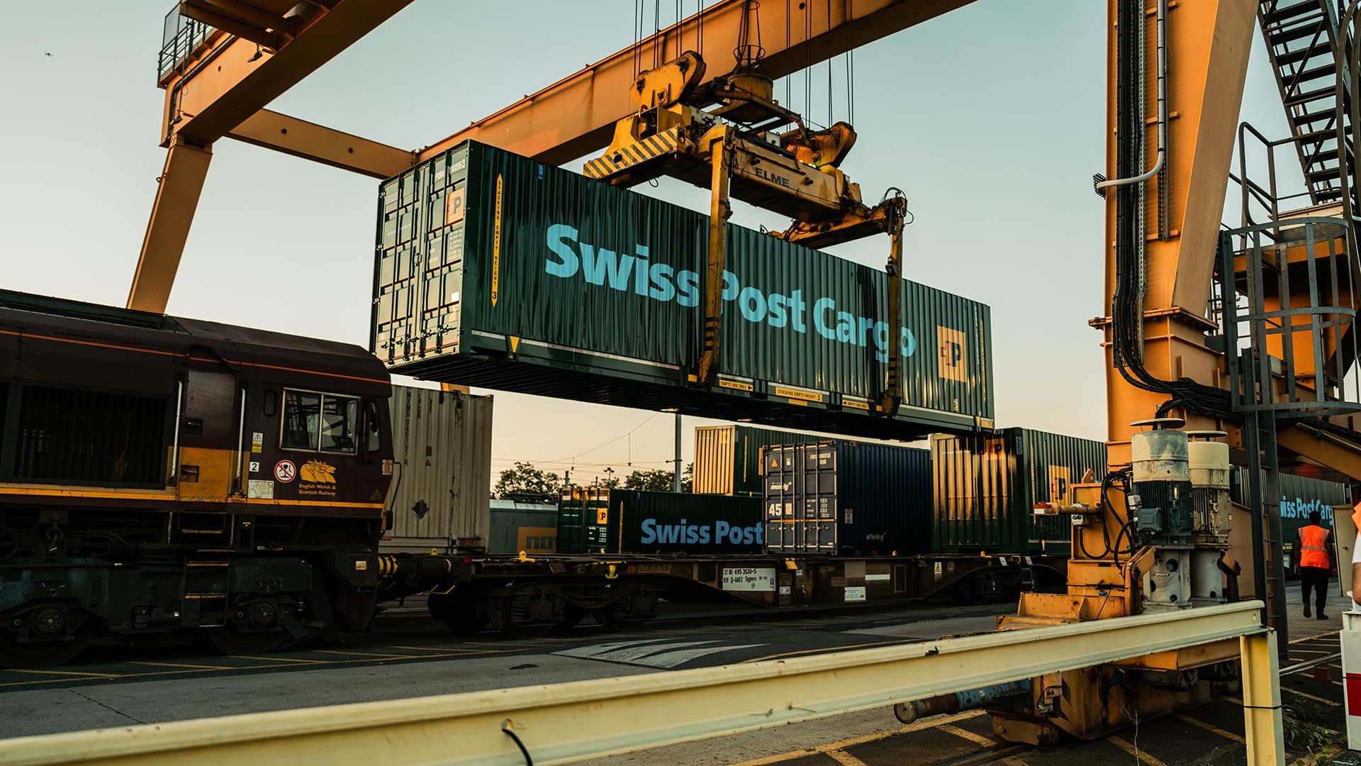 Swiss Post Cargo Container wird auf Zug verladen