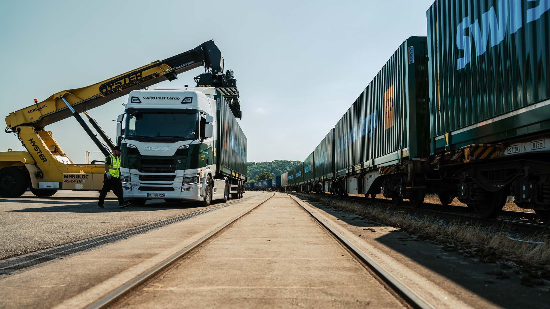 Le conteneur est chargé du camion sur un train de marchandises au terminal.