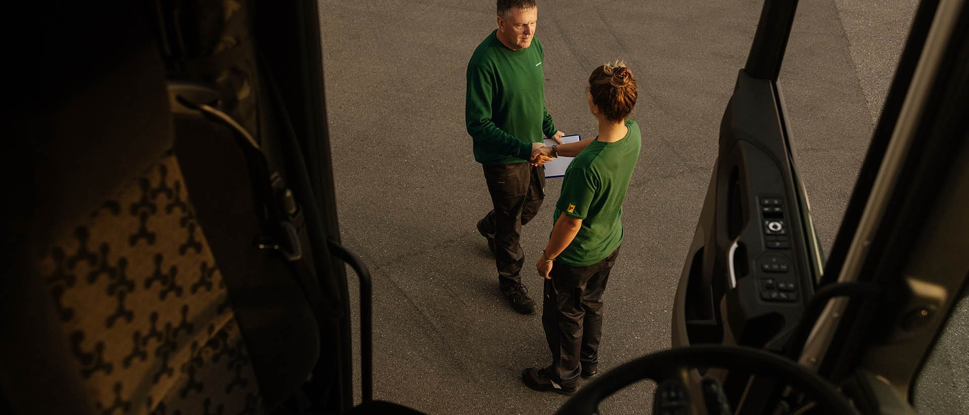 Two Swiss Post Cargo employees greet each other (photographed out of an open lorry).