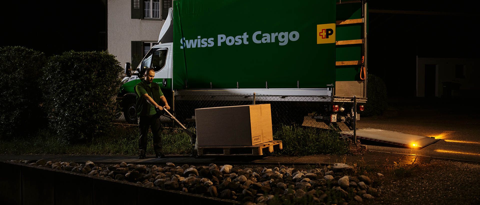A Swiss Post Cargo driver unloads spare parts that are directly delivered overnight to customers in agriculture and industry.