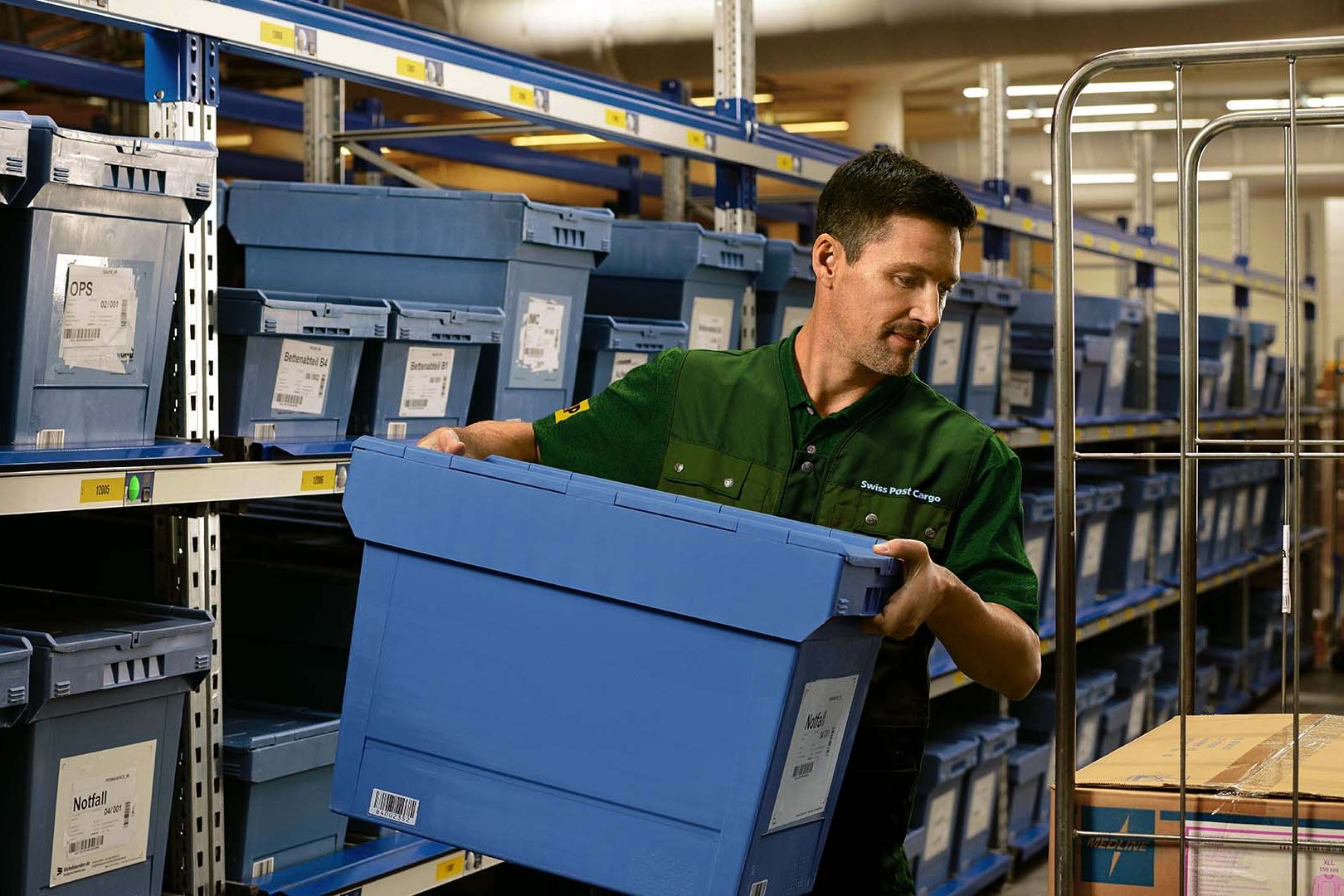 Un employé d’entrepôt transporte des marchandises dangereuses à l’aide d’un transpalette dans l’entrepôt de matières dangereuses.