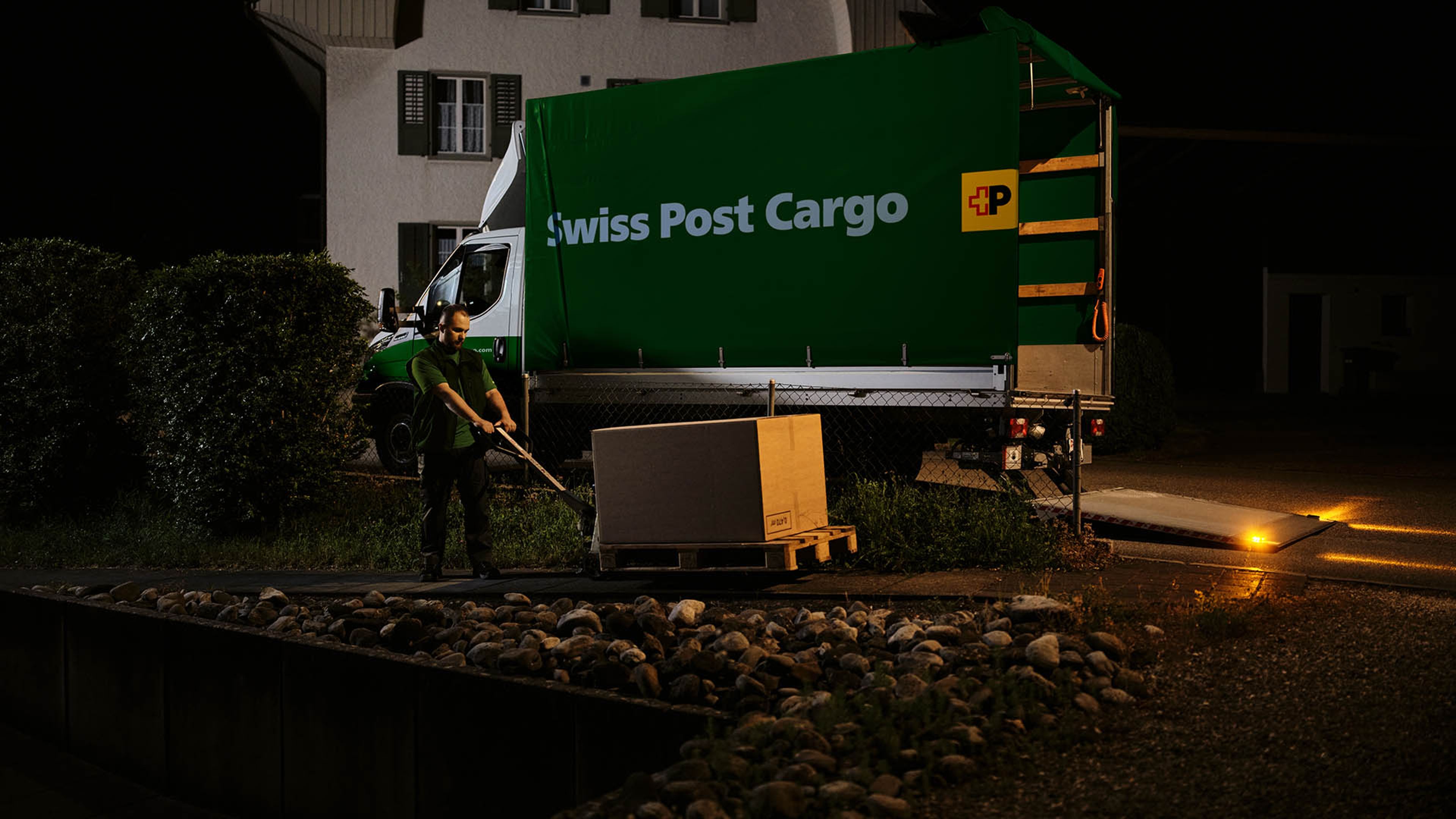 A Swiss Post Cargo driver unloads spare parts that are directly delivered overnight to customers in agriculture and industry.