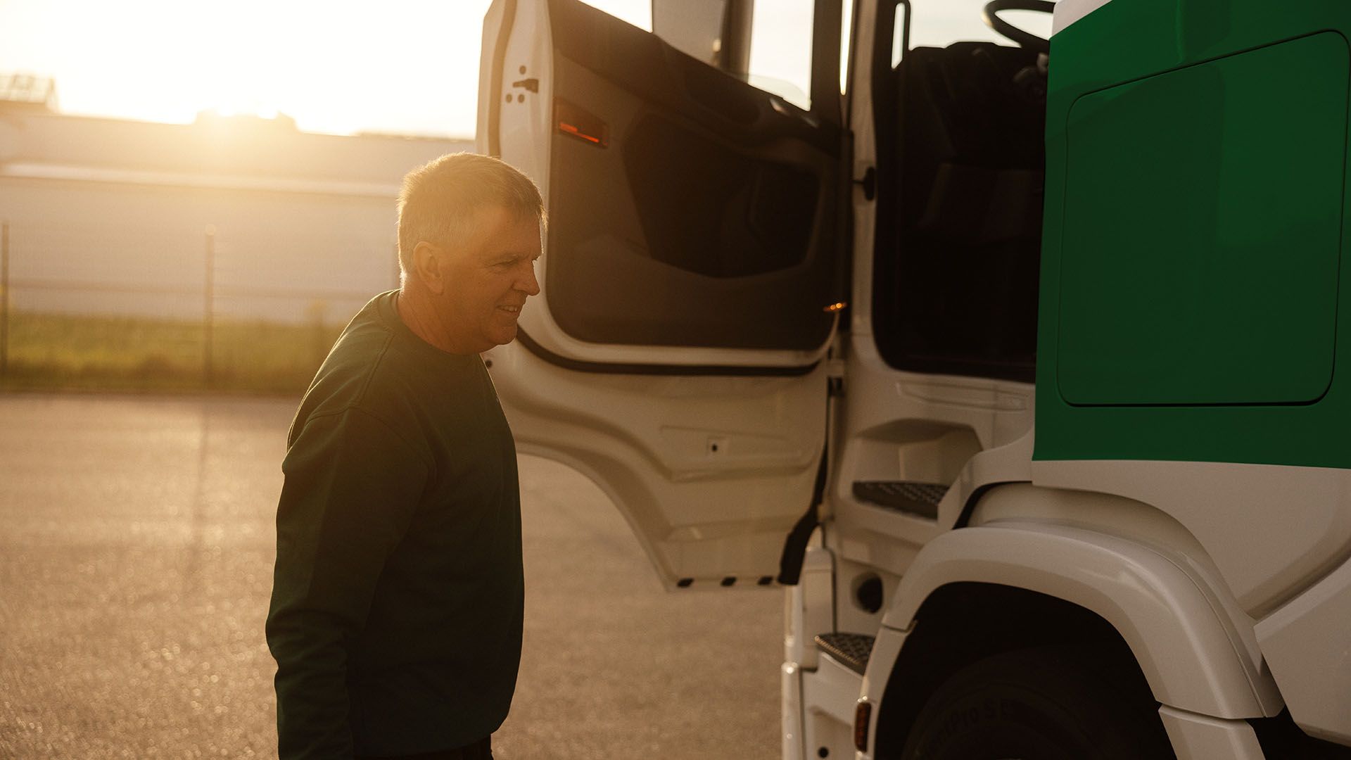 Ein Swiss Post Cargo Fahrer schliesst die Tür eines LKW.