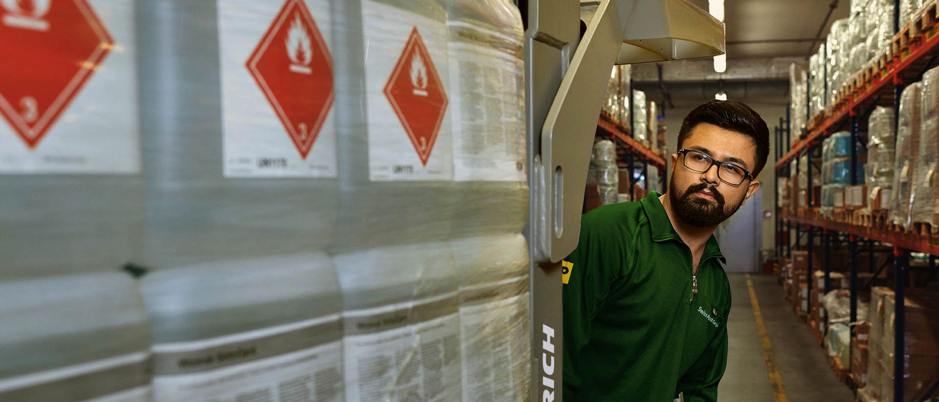 Un magazziniere trasporta merci pericolose su un transpallet nel magazzino delle sostanze pericolose.
