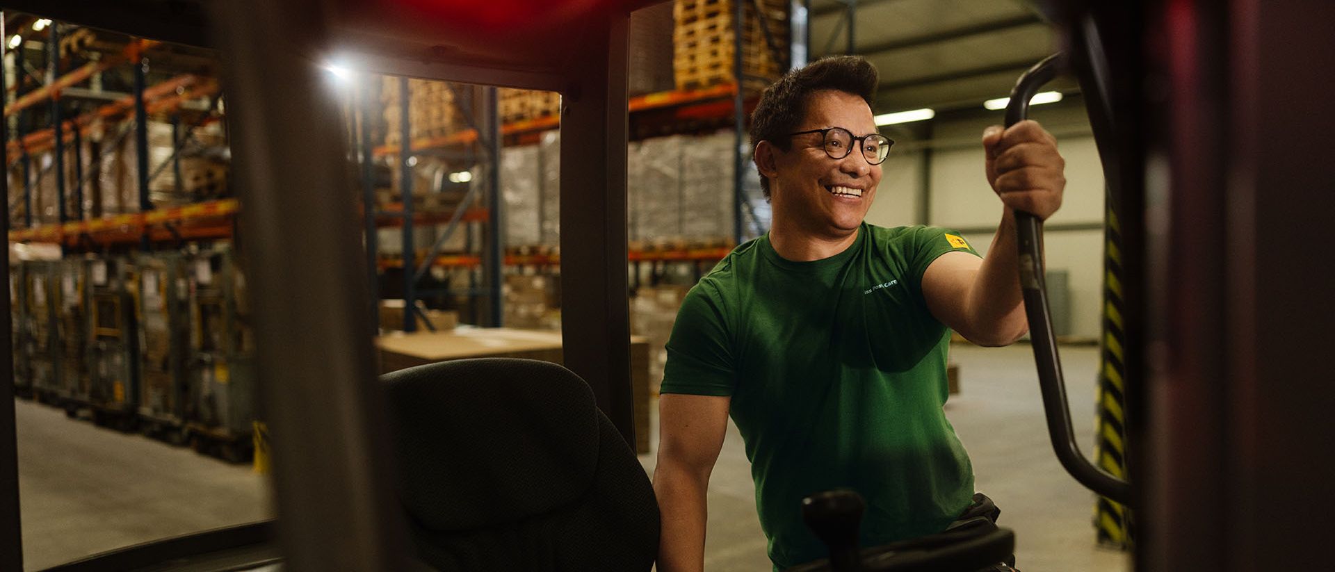 In a warehouse, a Swiss Post Cargo employee gets into the cabin of a forklift.