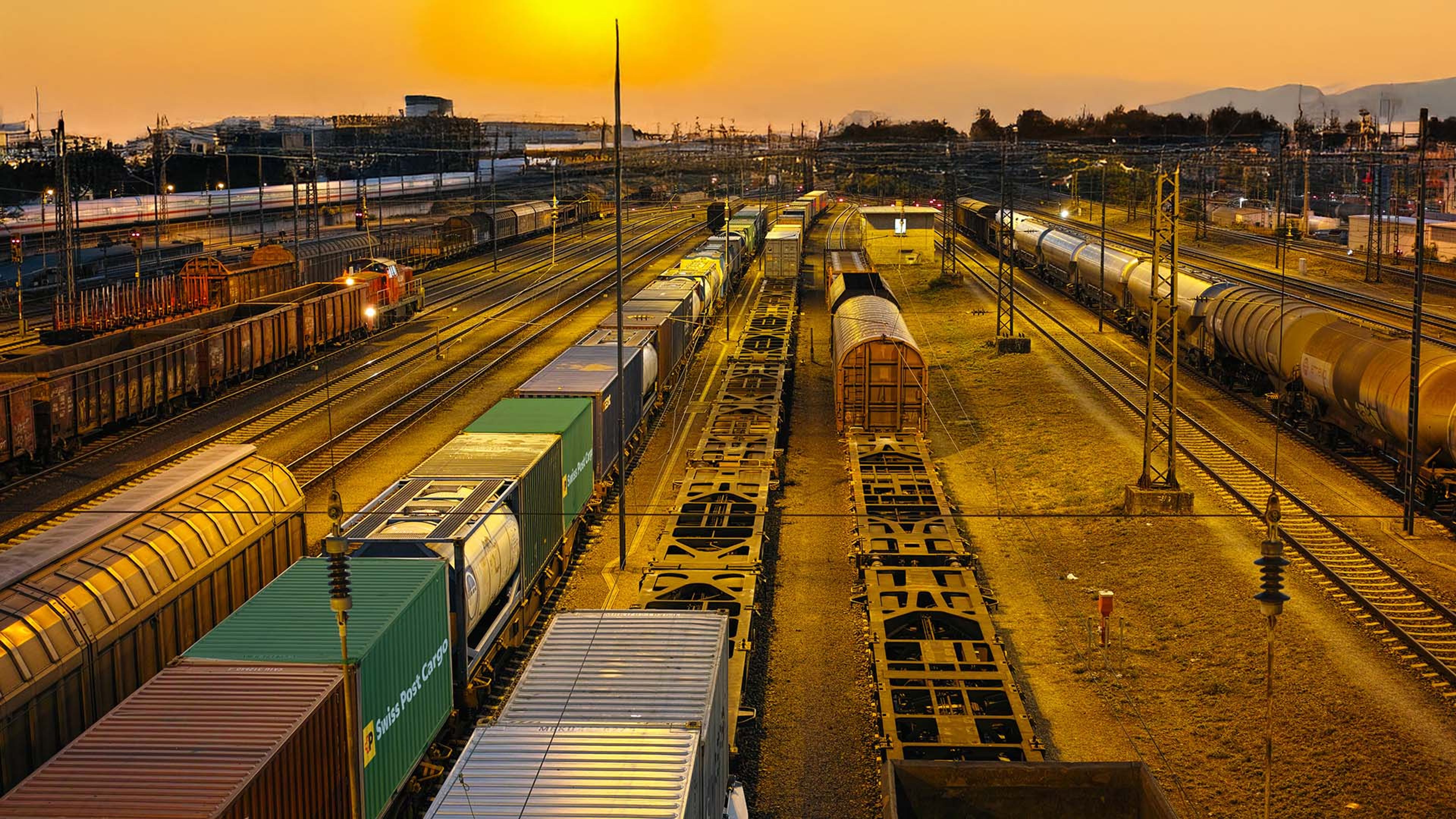Conteneurs Swiss Post Cargo sur un train en marche au crépuscule