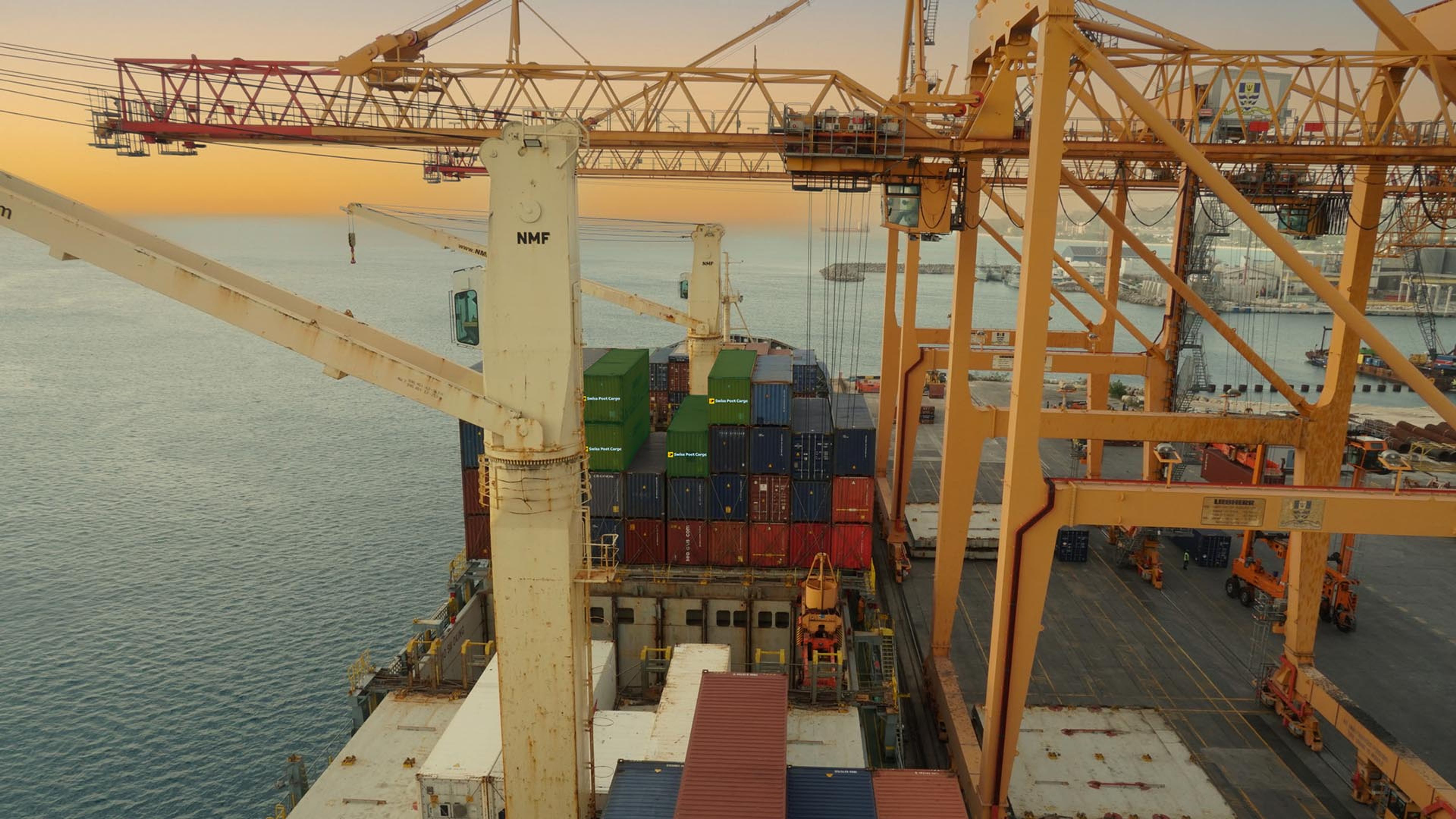 Swiss Post Cargo container under a cargo crane in the port