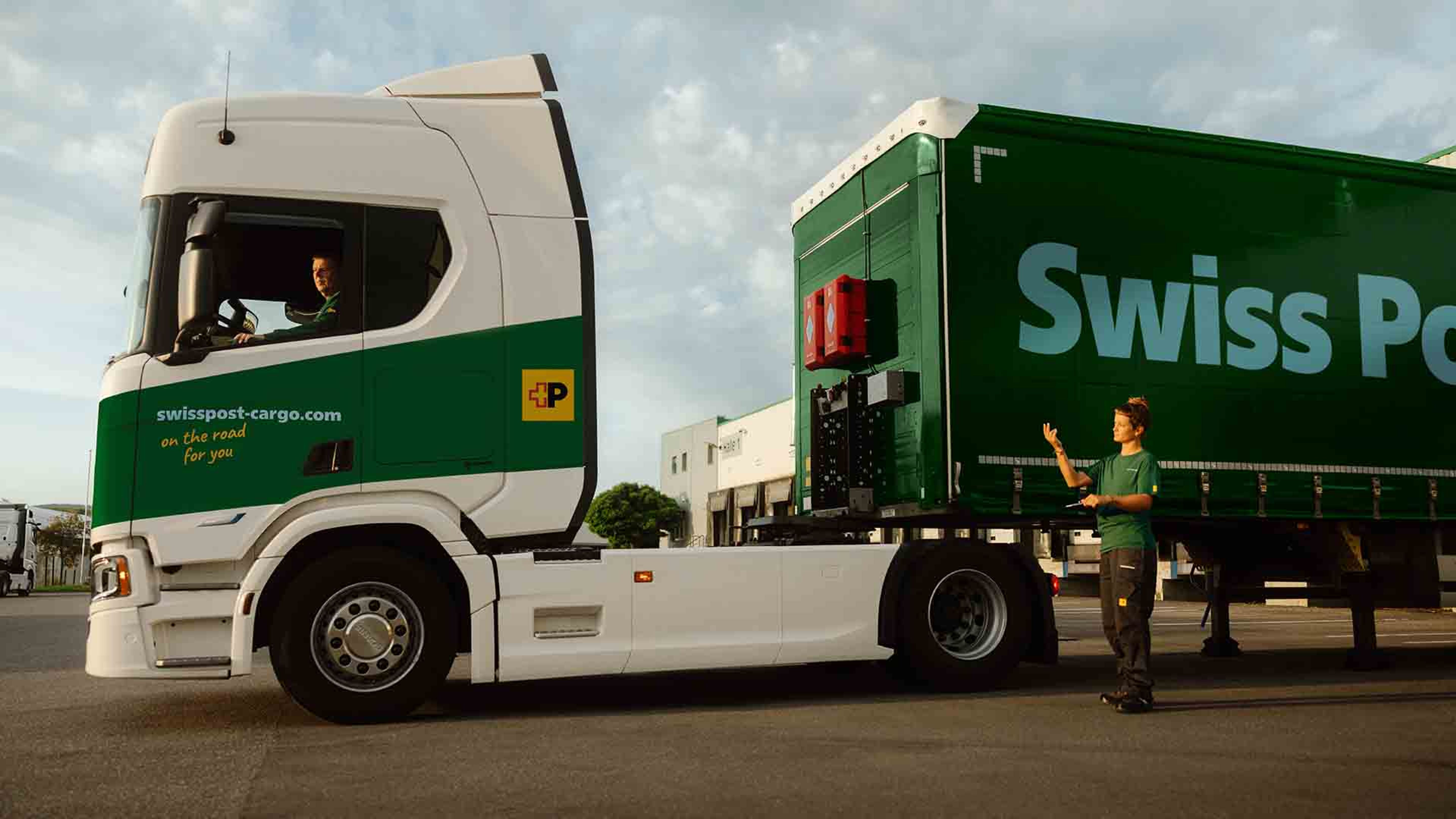 A Swiss Post Cargo truck driver couples a trailer with the help of a colleague.