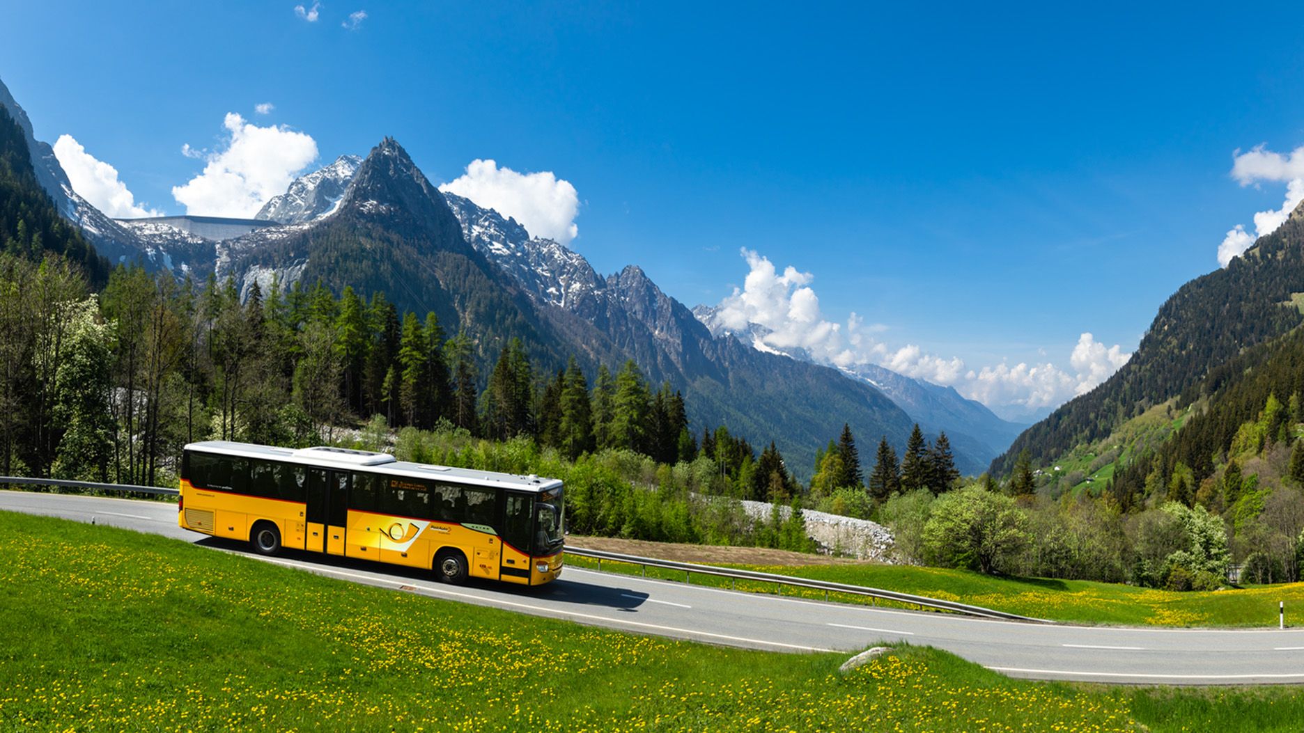 A Postbus in a summer mountain landscape.