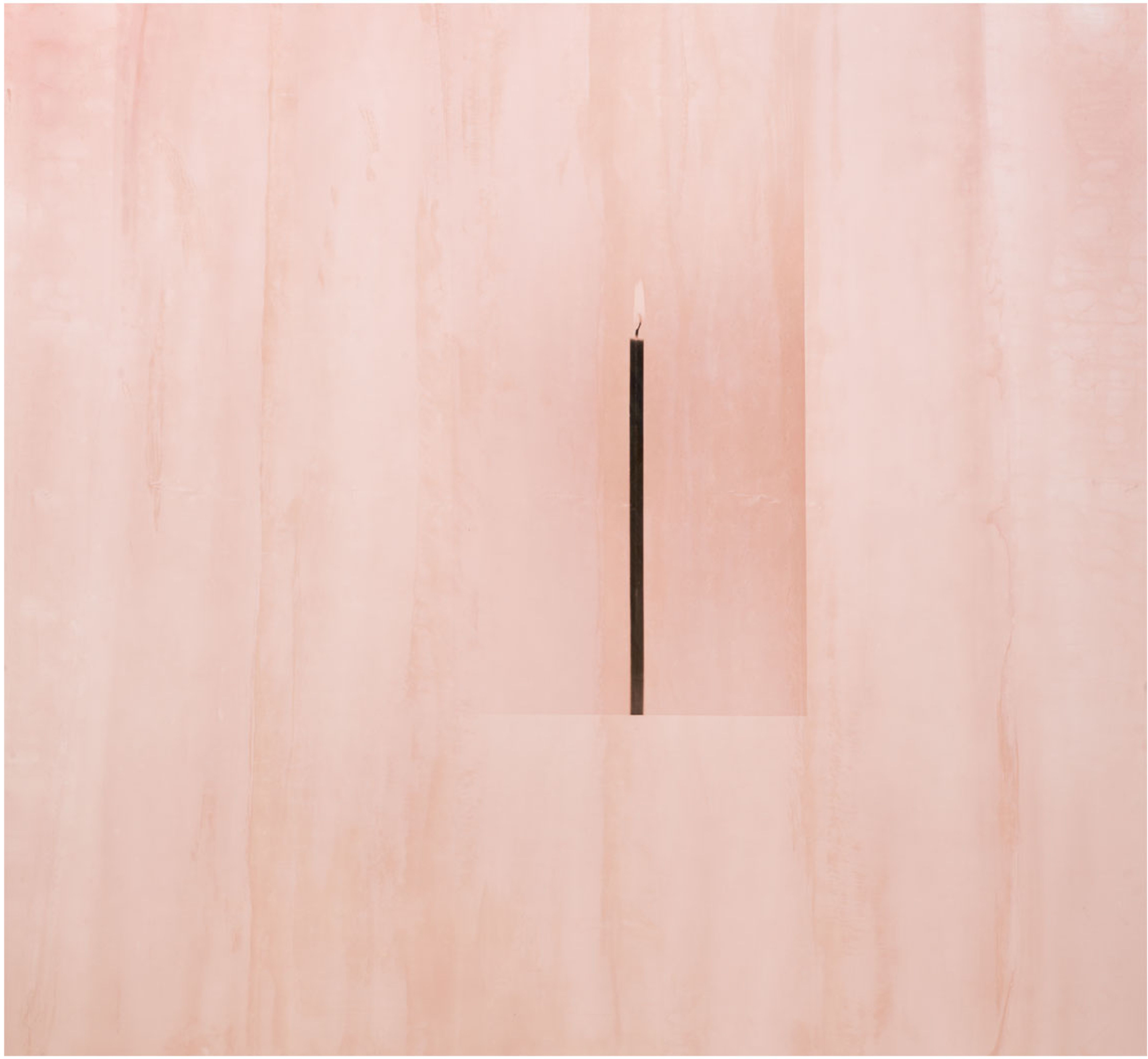 Eine einzelne schwarze Kerze mit Flamme in rosa Umgebung.