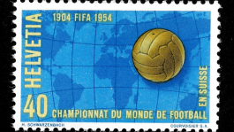Timbre suisse pour la Coupe du Monde de football 1954. Le timbre montre un ballon doré sur une carte du monde bleue. Texte : ‘1904 FIFA 1954’, ‘Helvetia’, ‘40’ et ‘Championnat du Monde de Football en Suisse’.