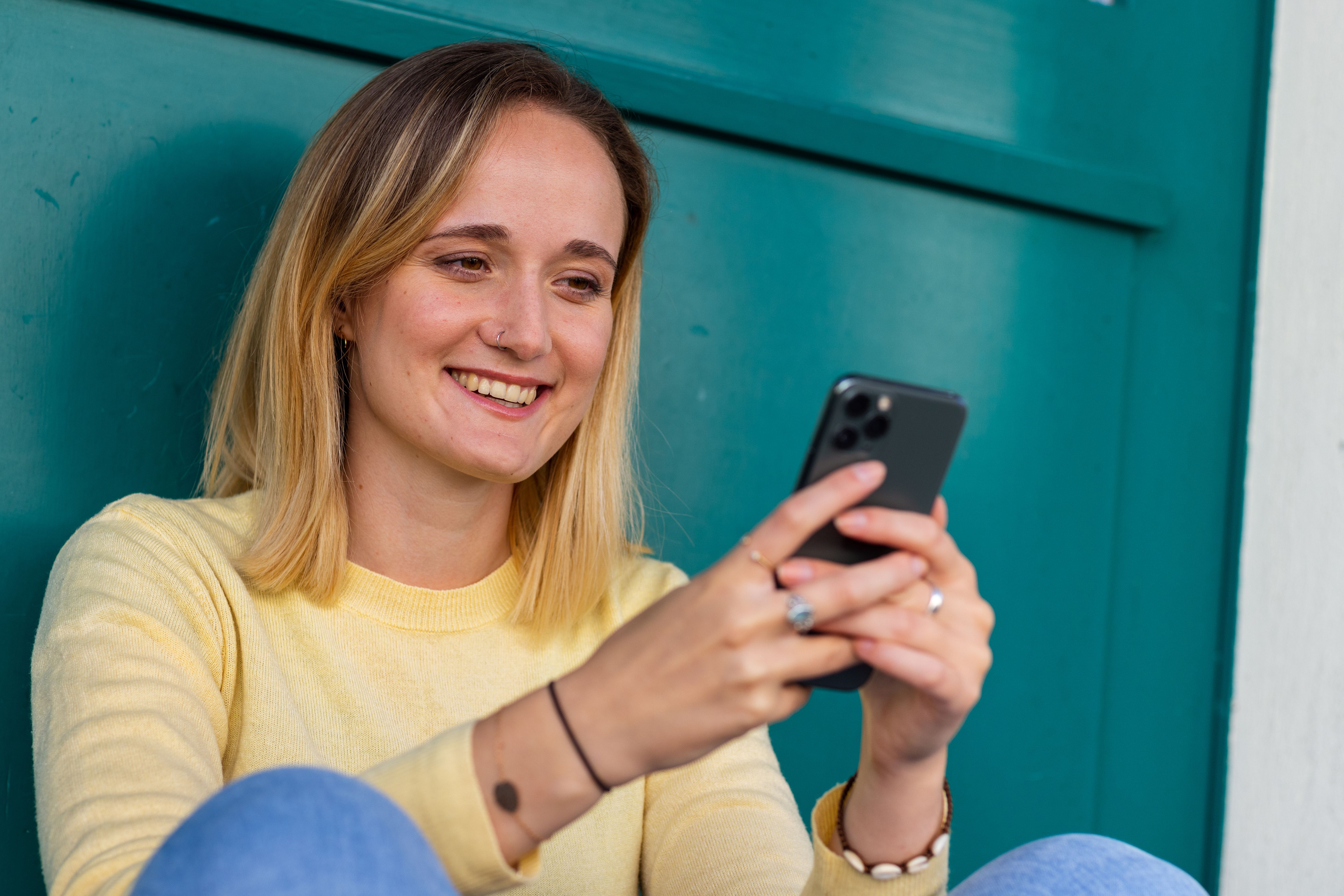 Frau ist lächelnd am Handy