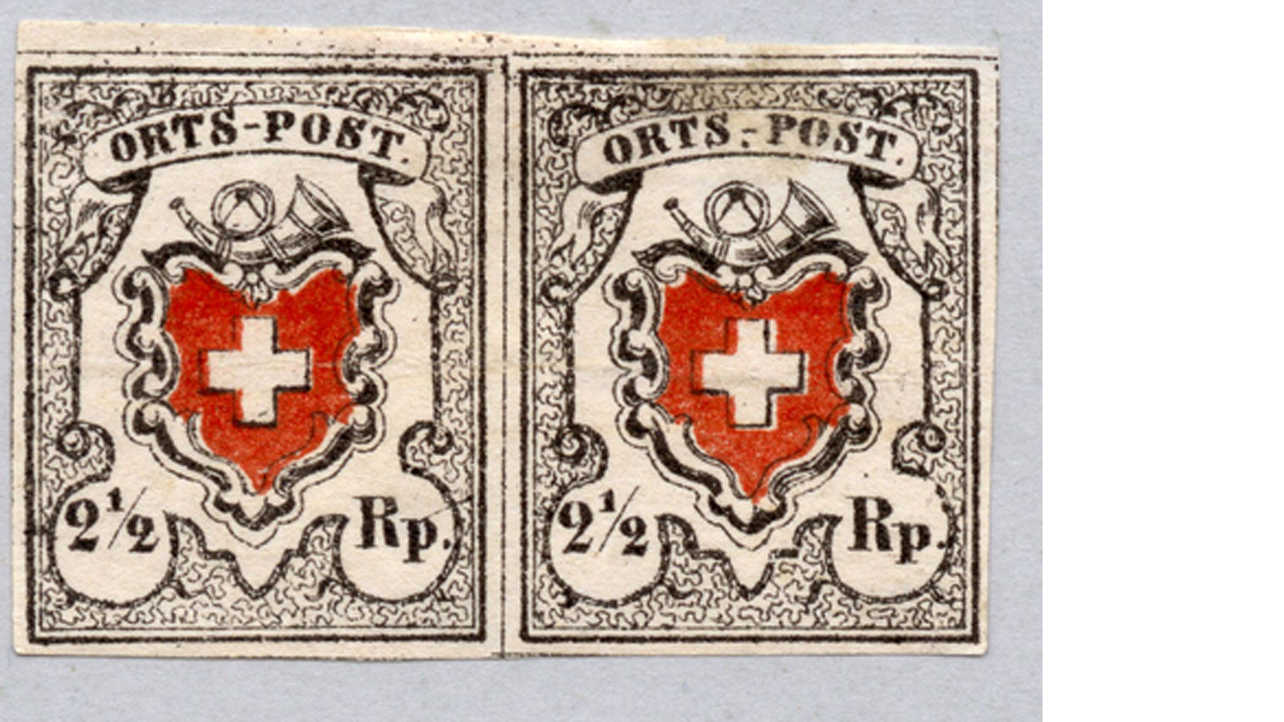 Die ersten schweizweit gültigen Briefmarken: Schweizerkreuz, Posthorn und Wertangabe 2 ½ Rappen.