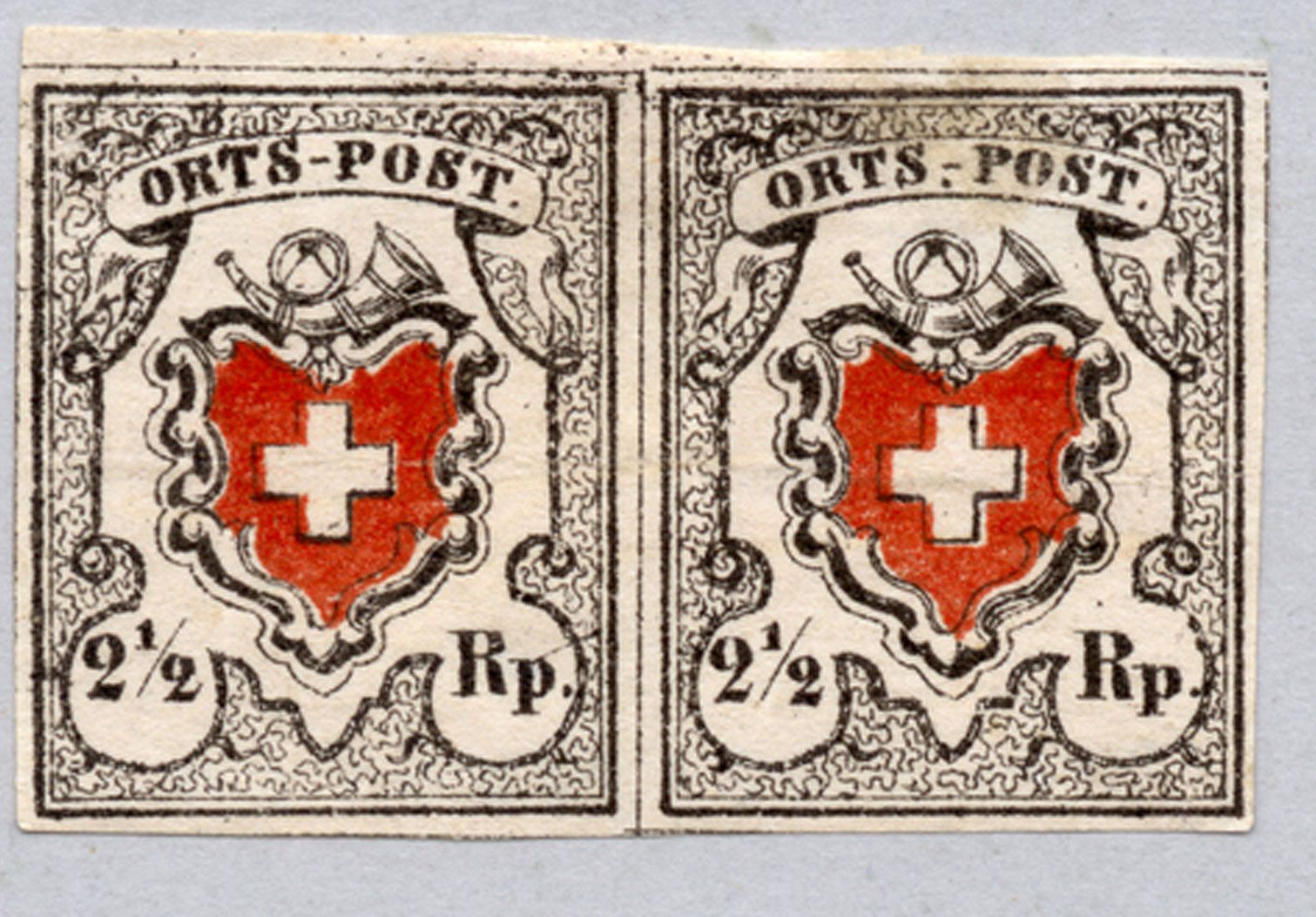 Die ersten schweizweit gültigen Briefmarken: Schweizerkreuz, Posthorn und Wertangabe 2 ½ Rappen.