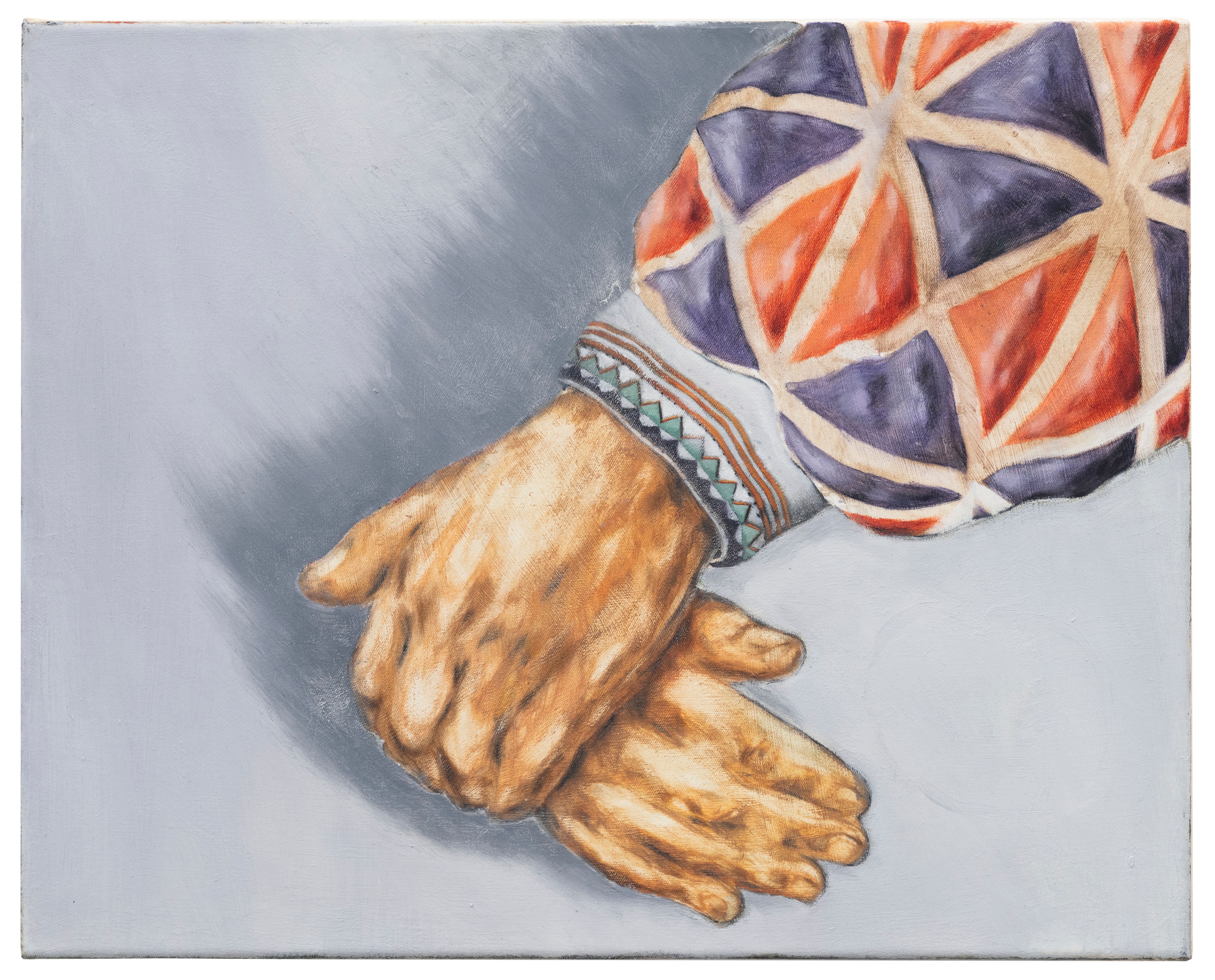 Two folded hands against a grey background with patterned sleeves.